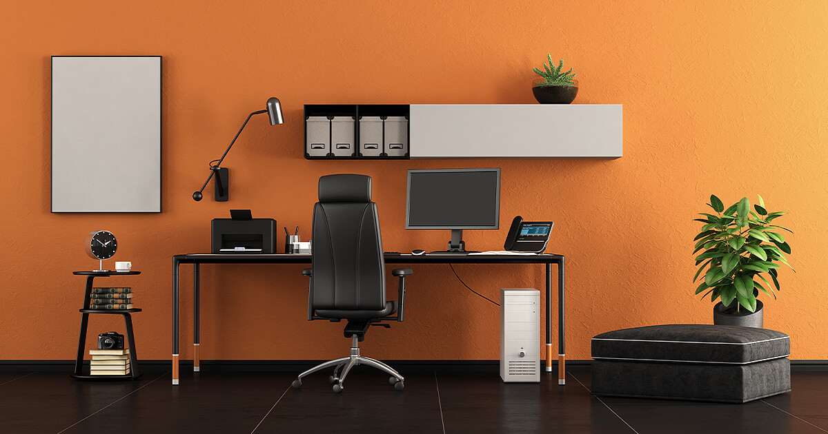 Spacious home office against vibrant orange wall