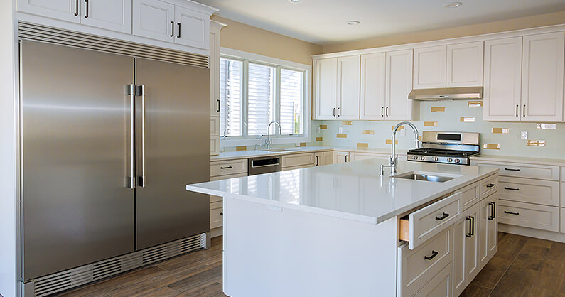 Custom kitchen cupboards in white with large fridge