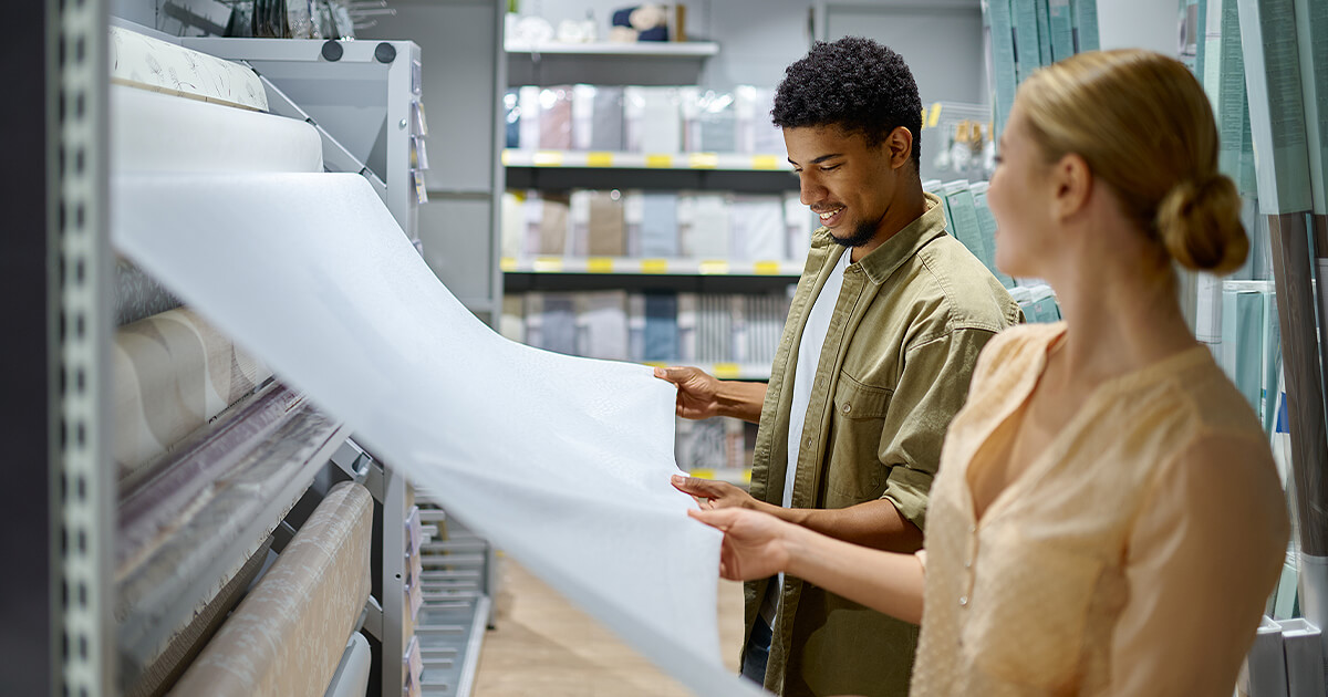 Couple looking at huge amount of wallpaper options for home office