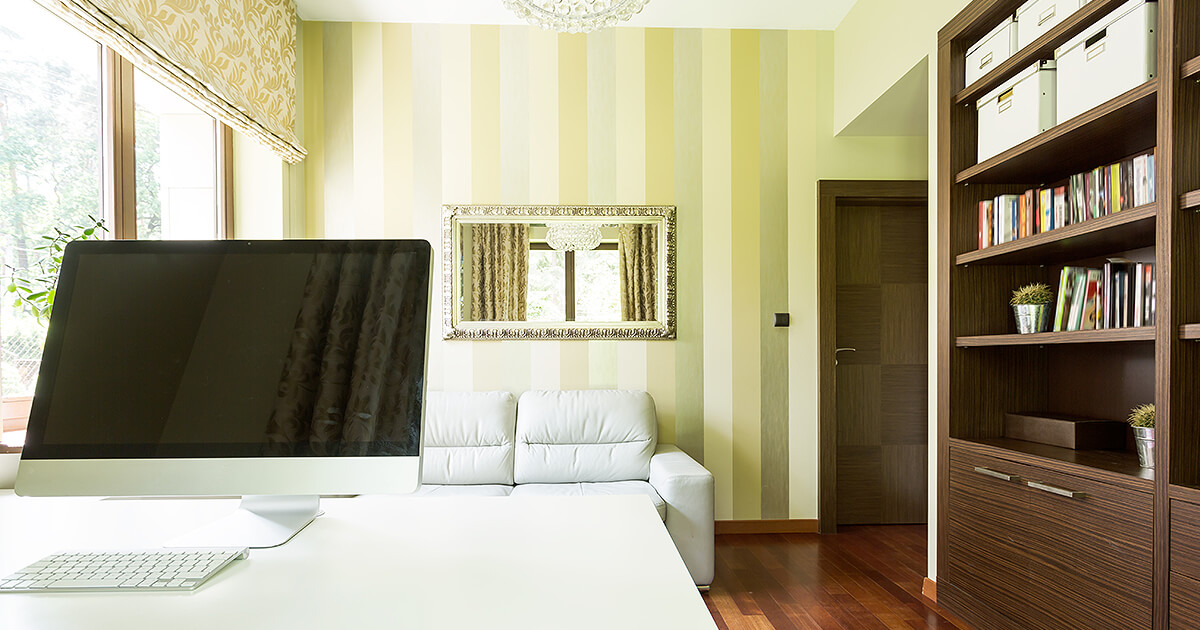 Home office with timber shelving and classy stripy wallpaper in green tones