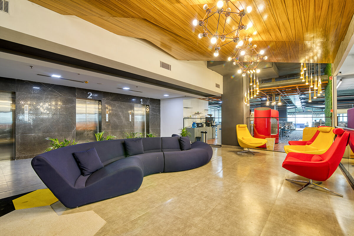 Bright orange and red chairs next to large navy, trendy couch in office entryway