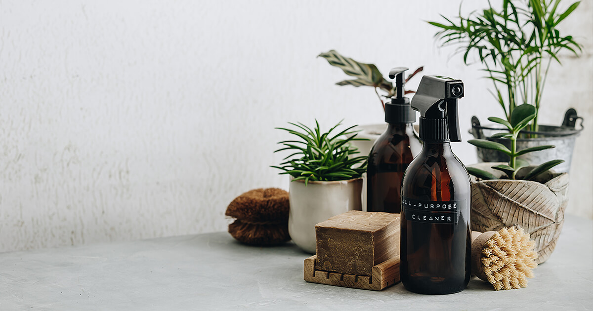 Bottles of natural cleaner with plants and organic cleaning products