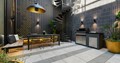 Designer courtyard in modern home with dark tiles, gold accents and green plants throughout with circular feature stairs in back corner