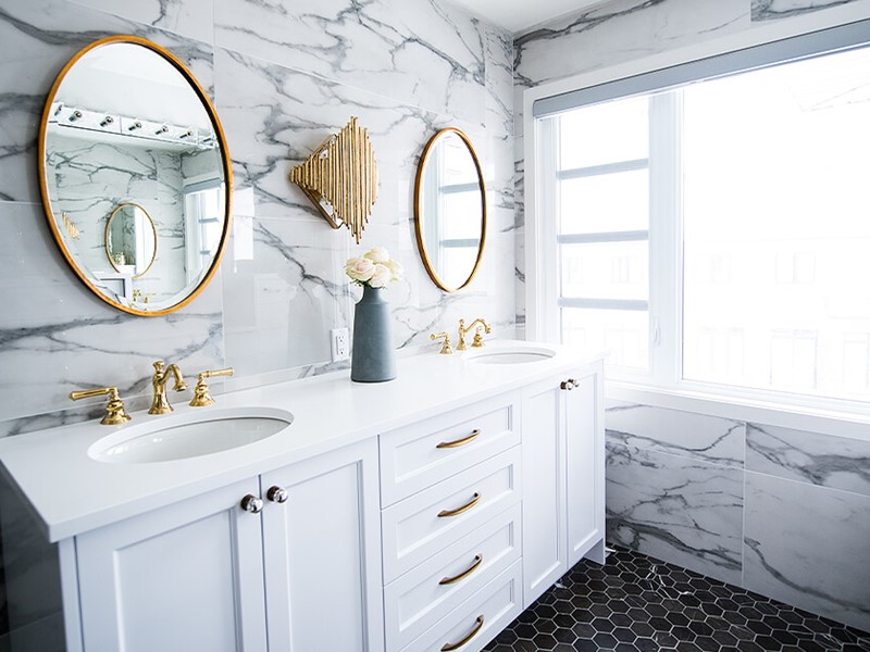 White bathroom with classic fixtures and white and black marble look tile walls