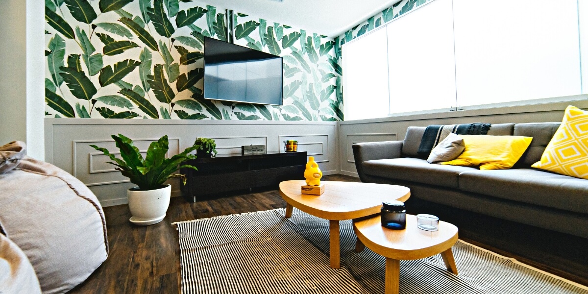 Living room with black custom cabinetry and green leaf wall paper