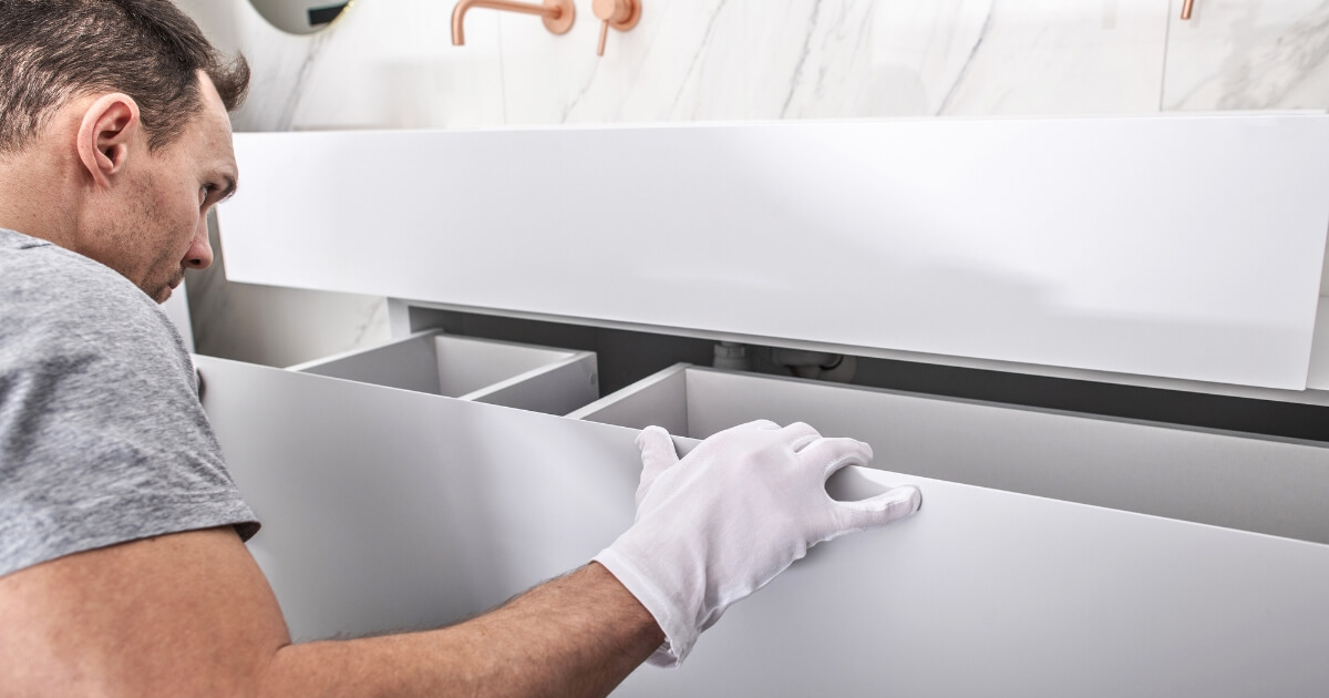 Contractor putting in a bathroom sink cabinet