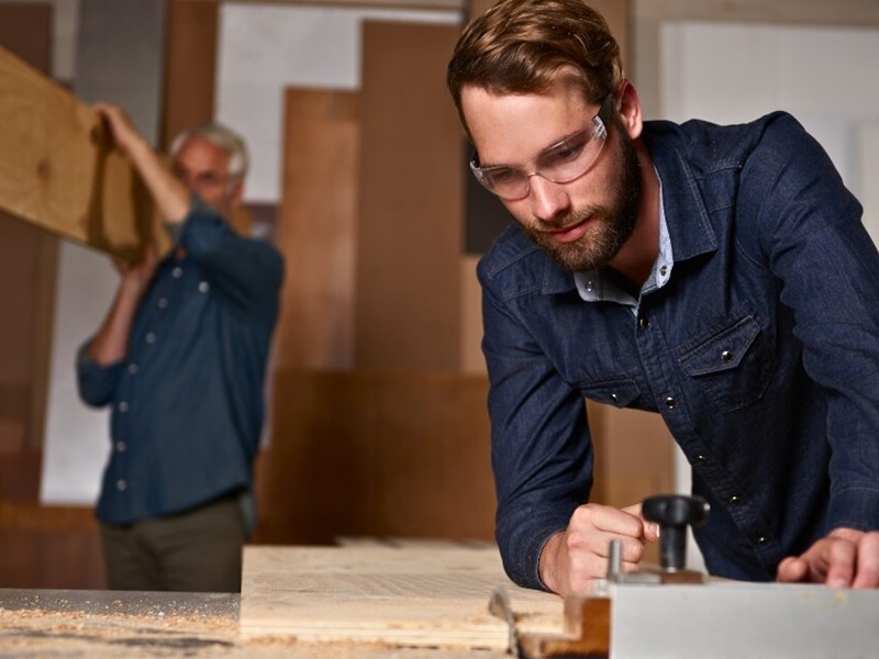 Man working as a cabinet maker with wood