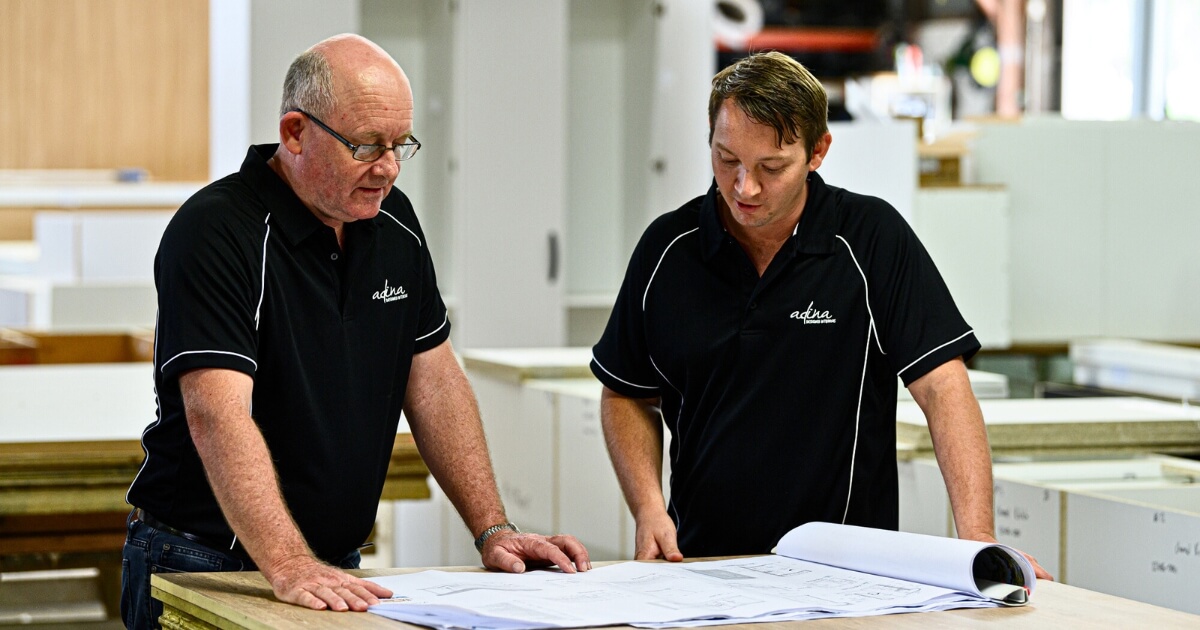 Two cabinet makers discussing client needs