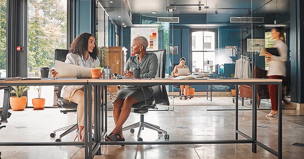 Two women sitting in a modern commercial office design layout