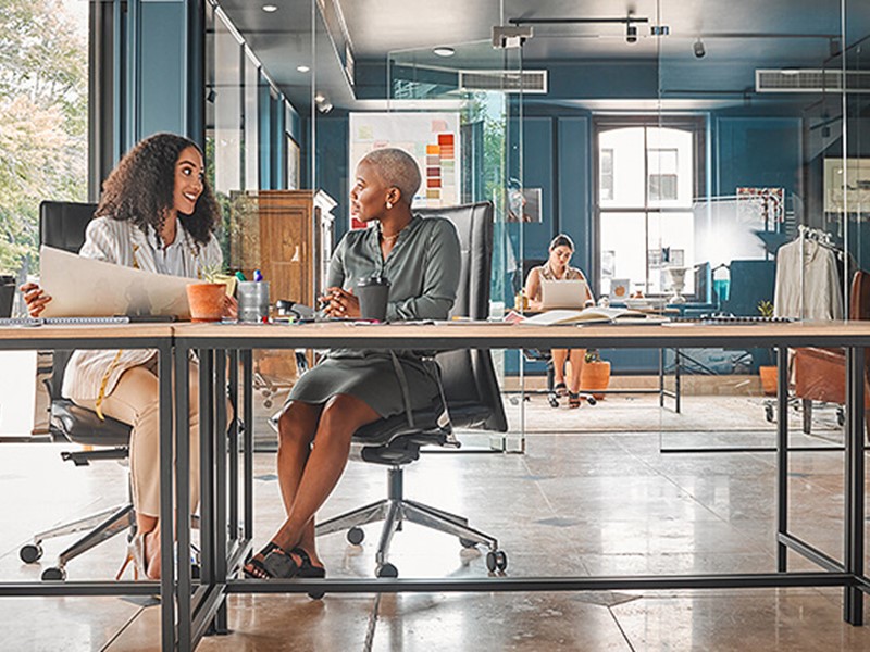 Two women sitting in a modern commercial office design layout