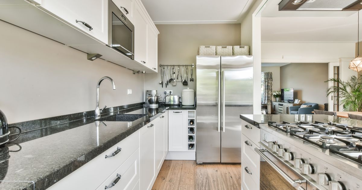 Galley kitchen with fridge at end