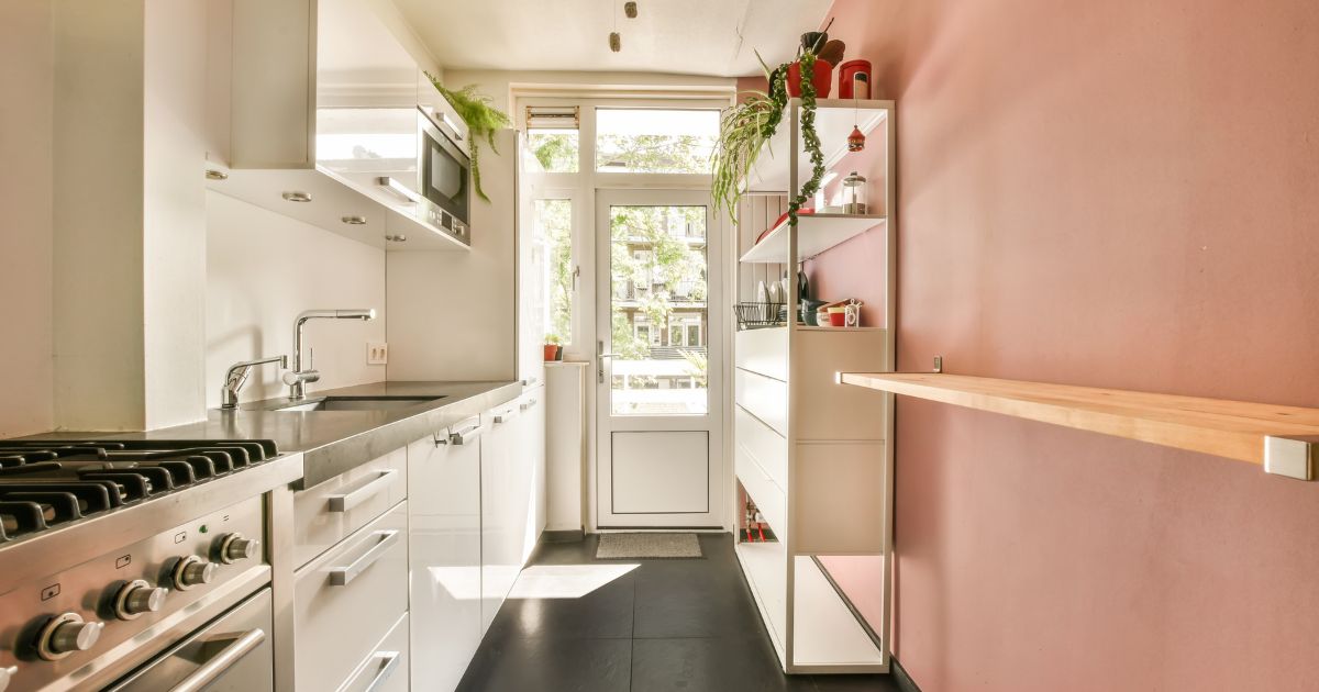 Galley kitchen with pink wall